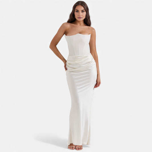 Woman wearing a strapless white dress on a plain background